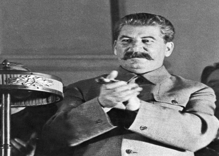 Stalin, 8. Sovyet Kongresi sırasında SSCB\'nin yeni anayasa taslağı hakkındaki raporu tartışan bir üyeyi alkışlıyor.